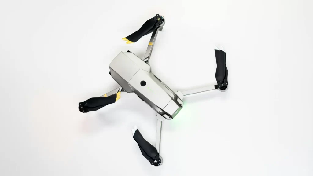 Overhead shot of a quadcopter drone with folded propellers on a clean white background.